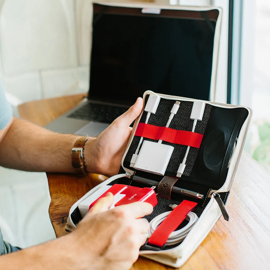 Läderinbunden Twelve South BookBook CaddySäck som rymmer MacBook-laddare, kablar och adaptrar i organiserade fack.