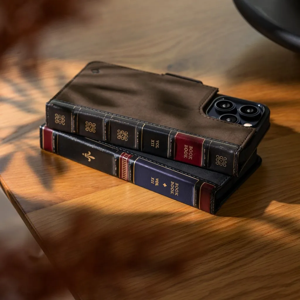 Man som håller i en snygg Twelve South BookBook med MagSafe, ett iPhone 14 Plus-fodral och en plånbok i brunt läder.