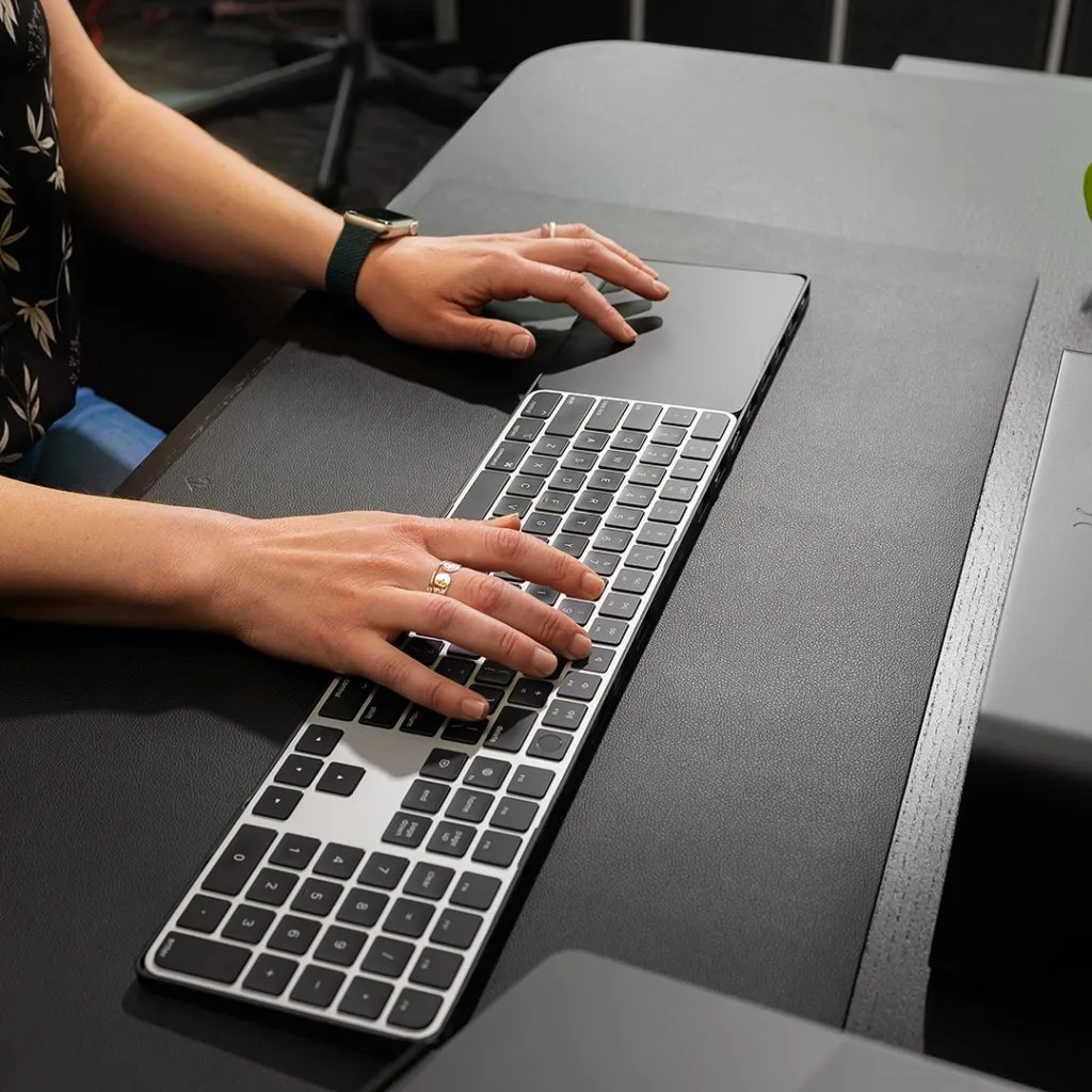 Svart Twelve South DeskPad tillverkad av veganläder som ger komfort för tangentbordsanvändning och precisionsmuspekning på en arbetsplats.