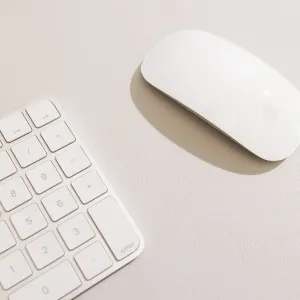 Twelve South DeskPad hiirematt koos laiendatud klaviatuuriga ja Apple’i hiirega heledal tööpinnal.
