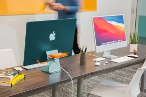 Twelve South BackPack 4 shelf on iMac stand with orange external drive, adding hidden storage behind the display.