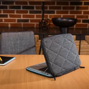 Twelve South SuitCase -kovakuorinen suojakotelo avoinna MacBook Pro 16:n ympärillä puupöydällä, harmaa tikattu muotoilu näkyvissä