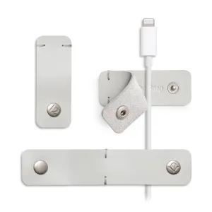 Twelve South CableSnap Stay kabelholdere i læder i duegrå med tryklåse og et hvidt Lightning-kabel