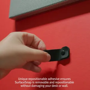 Twelve South CableSnap Stay kabelholder, der trykkes fast med hånden på en plan overflade