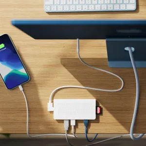 Twelve South StayGo USB-C-hub i hvitt på et skrivebord med tilkoblede kabler, Ethernet og et minnekort satt inn