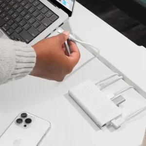 Twelve South StayGo USB-C Hub på et hvitt skrivebord, koblet til en bærbar datamaskin med flere hvite kabler tilkoblet.
