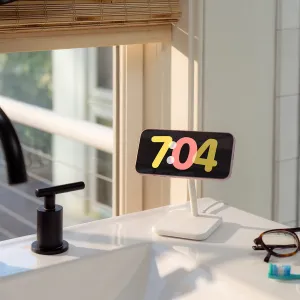 Twelve South HiRise 2 Deluxe hvitt trådløst ladestativ som holder en telefon liggende på en benkeplate