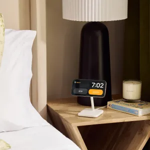 Twelve South HiRise 2 Deluxe trådløst ladestativ som holder en telefon i liggende format på et nattbord