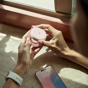 Twelve South Butterfly™ SE taitettava vaaleanpunainen langaton 2-in-1-laturi avattuna iPhonen vieressä