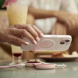 Twelve South butterFly SE vaaleanpunainen taitettava langaton laturi, jossa puhelin ja Apple Watch pöydällä