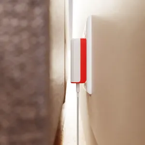 Twelve South PlugBug 50 W:n USB-C-seinälaturi valkoisena ja punaisena, kytkettynä pistorasiaan kaapeli liitettynä