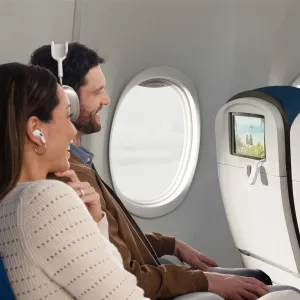 Twelve South AirFly Pro 2 Deluxe kytkettynä lentokoneen istuimen selkänojan näyttöön langatonta lennonaikaista ääntä varten.