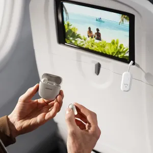 Twelve South AirFly Pro 2 Deluxe langaton äänilähetin liitettynä istuimen selkänojan näyttöön, Bose-nappikuulokkeet kädessä