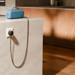 Twelve South PowerCord 1,2 m USB-C PD -laturi EU-pistokkeella antaa virtaa siniselle kannettavalle kaiuttimelle.