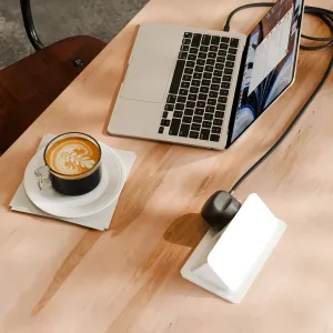 Twelve South -merkin punottu USB-C-virtajohto, jossa on integroitu EU-laturi, liitettynä kannettavaan tietokoneeseen työpöydällä