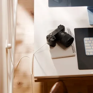 Twelve South USB-C-virtajohto on kytketty pistorasiaan ja lataa pöydällä olevaa kameraa