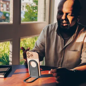 Twelve South Curve Nano, soporte magnético plegable para teléfono que sostiene un smartphone en vertical sobre una mesa de madera