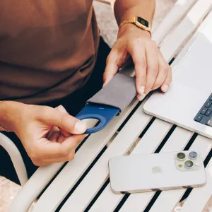 Twelve South Curve Nano vikbart magnetiskt telefonställ i kustblått bredvid en iPhone på ett bord