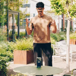 Twelve South Curve Nano hopfällbart telefonställ som håller en smartphone upprätt på ett utomhusbord