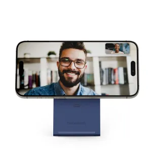 Twelve South Curve Nano hopfällbart telefonställ i kustblått som håller en smartphone i liggande läge för videosamtal
