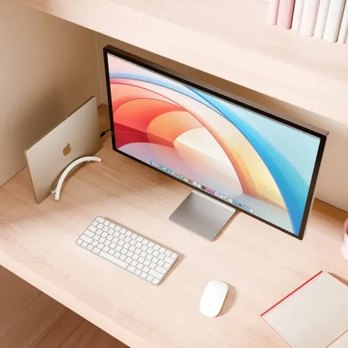 Twelve South BookArc Flex er et hvitt, buet vertikalt stativ som holder den bærbare datamaskinen oppreist på skrivebordet ved siden av skjermen.