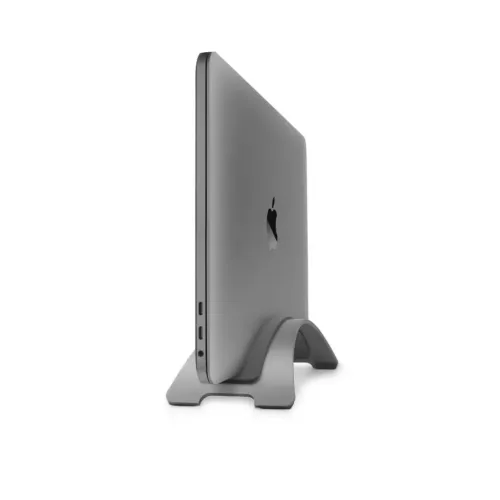 Twelve South BookArc holder en lukket MacBook vertikalt; to USB-C-porter, hodetelefonkontakt og buet stativ er vist på bildet.