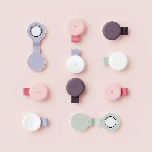 Twelve South ButterFly SE vikbar 2-i-1 laddare i flera färger, visad öppnad och stängd med runda laddytor på rosa bakgrund