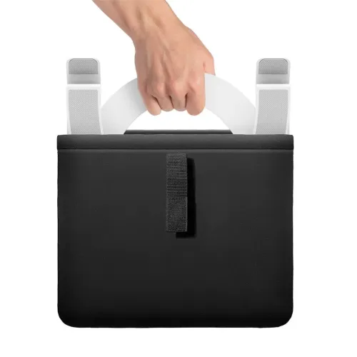 Twelve South Curve Flex, white curved laptop stand with two padded arms, held in hand and partially tucked into black case.