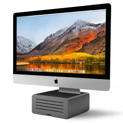 Twelve South HiRise Pro iMac-stativ som håller en silverfärgad iMac på en mörkgrå ventilerad skrivbordshöjare.