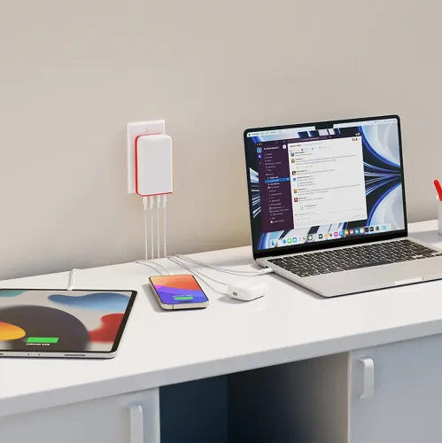 Twelve South PlugBug 120 W USB-C-laddare med fyra portar, ansluten till ett vägguttag och laddar en bärbar dator, en surfplatta och en telefon.
